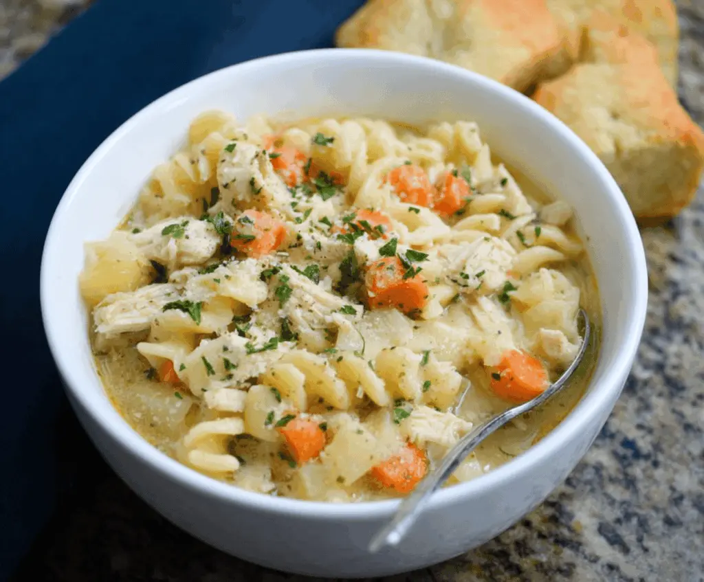 Creamy Parmesan Chicken Noodle Soup with tender chicken, vegetables, and pasta in a rich broth