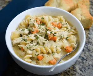 Creamy Parmesan Chicken Noodle Soup with tender chicken, vegetables, and pasta in a rich broth