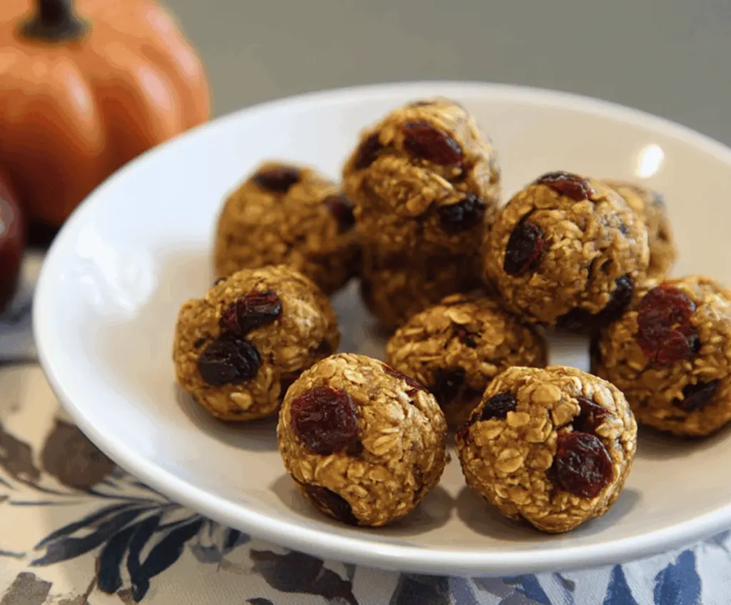 Healthy Pumpkin Cranberry Energy Bites with oats, dried cranberries, and pumpkin seeds in a white bowl, perfect for a nutritious snack