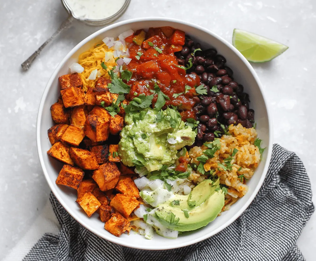Delicious chipotle sweet potato burrito bowl with fresh vegetables and spicy sauce.