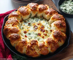 Baked Biscuit Wreath Dip served on a platter with fresh herbs and dipping sauces