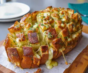 Delicious cheesy pull apart garlic bread with gooey melted cheese and aromatic garlic cloves.