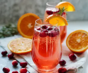 Frosty Cranberry Orange Prosecco Cocktail garnished with fresh cranberries and orange slices.