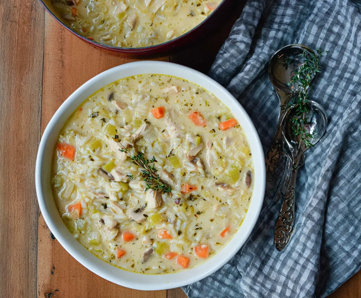 Creamy leek, chicken, and rice soup in a bowl with fresh herbs