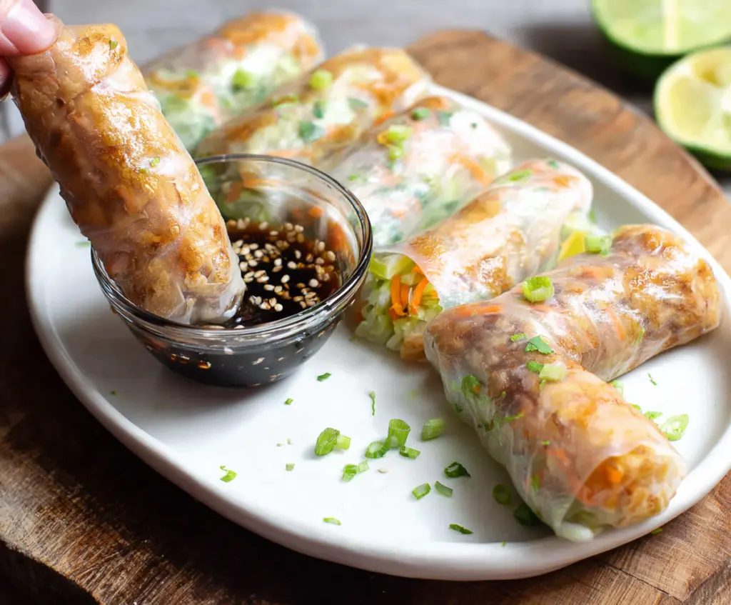 Crispy Air Fryer Rice Paper Rolls filled with fresh vegetables on a white plate.